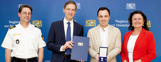 Das Foto zeigt: Regierungspräsident Rainer Haselbeck bei der Aushändigung der Christophorus-Medaille an Julian Bräuer. Mit ihrem Kommen zollten auch Niederbayerns Polizeipräsident Roland Kerscher und Landshuts Dritte Bürgermeisterin Jutta Widmann dem Lebensretter Dank und Anerkennung.